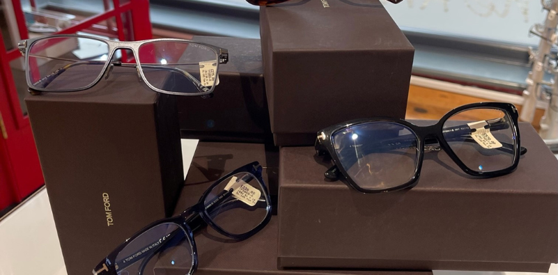 A selection of Tom Ford eyewear stacked on top of Tom Ford-branded eyewear boxes, in the window at Robinson Optometrists.