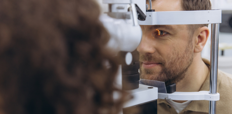 An optometrist looking into a patient’s eye during an eye exam.
