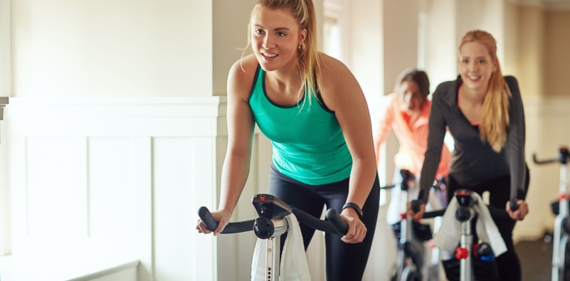 Women taking part in an indoor cycling exercise class